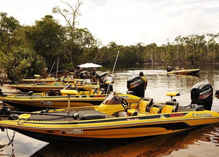 several bass boats from Amazon Xplor at the river