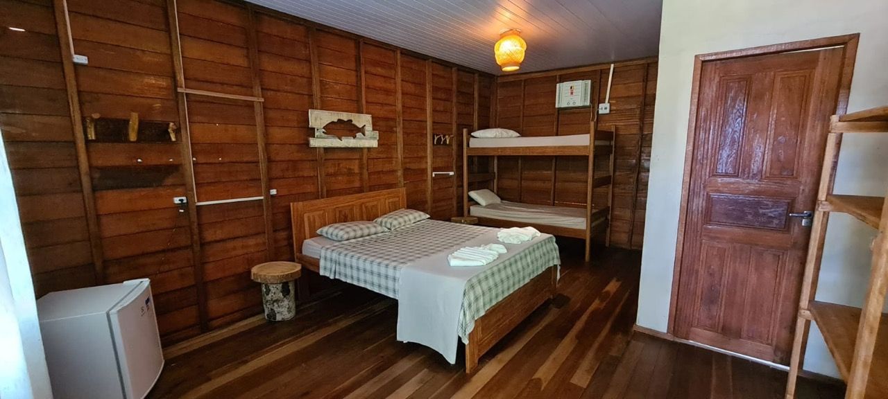 Quarto da pousada Sucunduri mostrando cama de casal e armário ao fundo