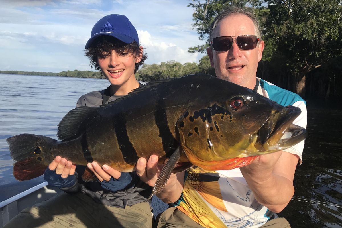 2 pescadores mostrando todo o contentamento com grande tucunaré-açu que pegaram / 2 anglers showing all their satisfaction with the large peacock bass they caught